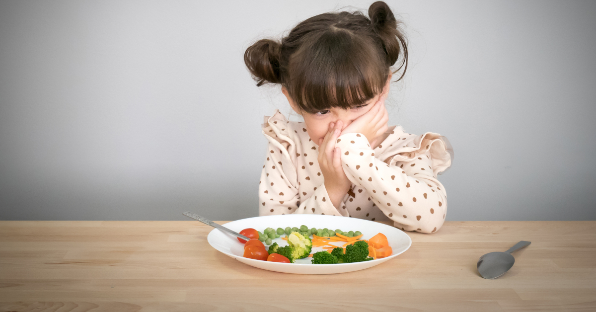 Bambina con piatto di verdure