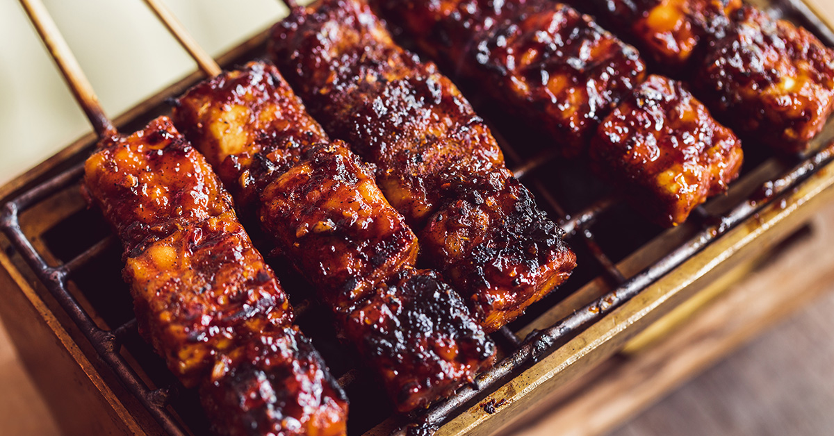 spiedini di tempeh grigliati e coperti di salsa barbecue