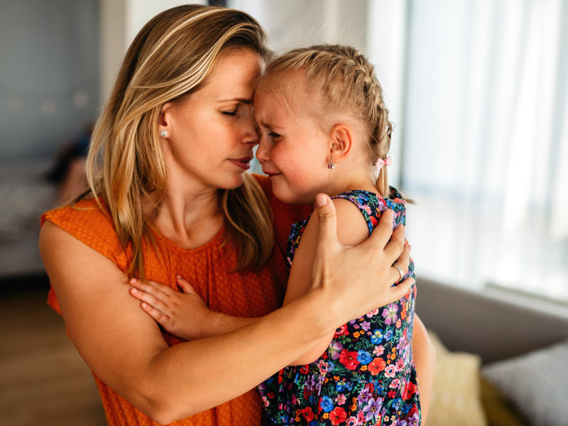 Bimba che piange in braccio alla sua mamma