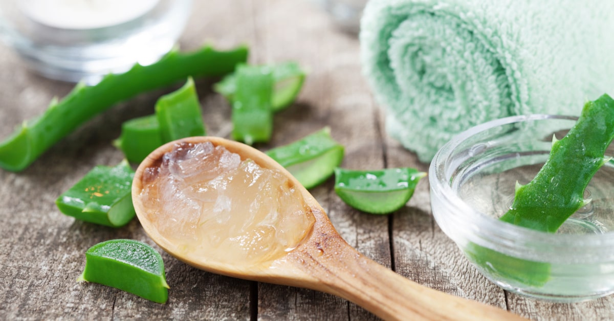 Foglia di aloe tagliata e gel su un cucchiaio di legno, prodotti per la spa e il benessere