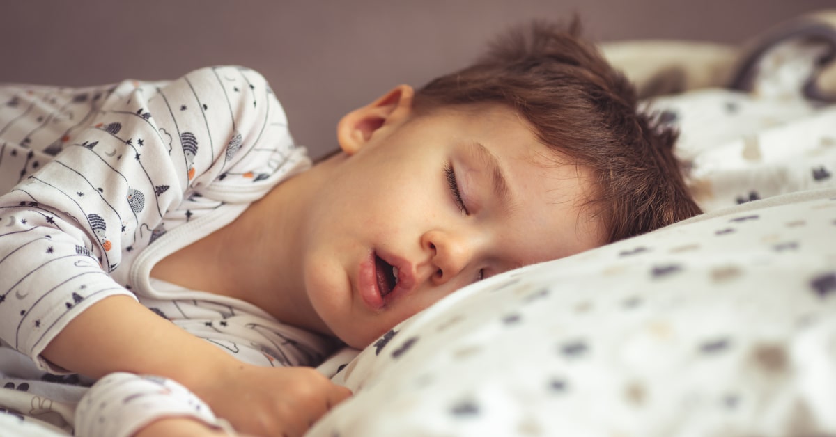 Bambino che dorme nel suo letto