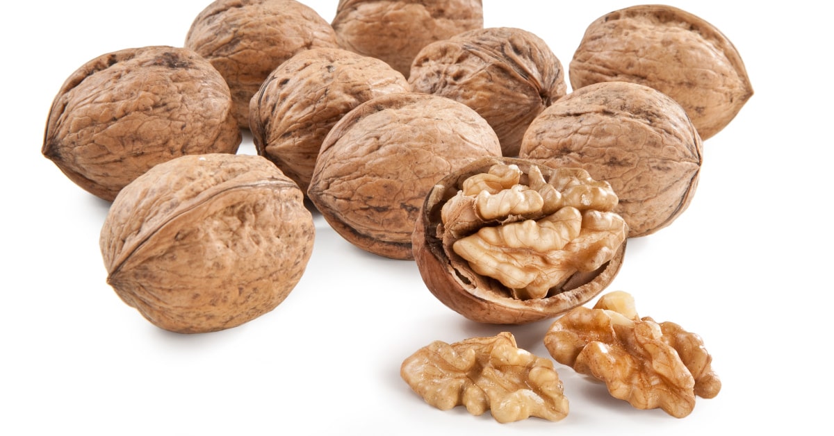 Noci in guscio e gherigli su sfondo bianco