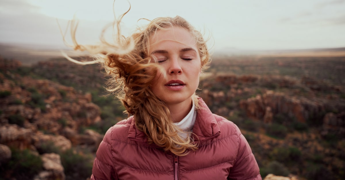 Donna all'esterno con capelli spettinati dal vento forte