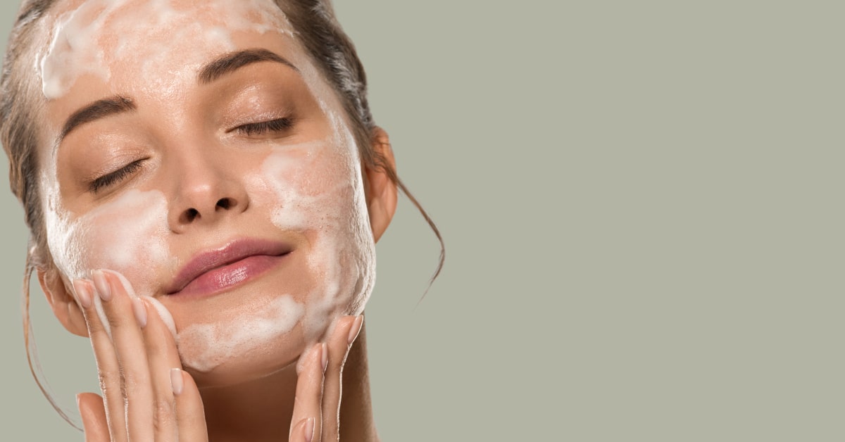 Donna che si deterge il viso con prodotti naturali