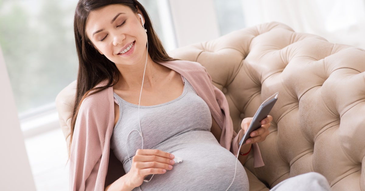 Donna in gravidanza mentre ascolta musica rilassante per musicoterapia