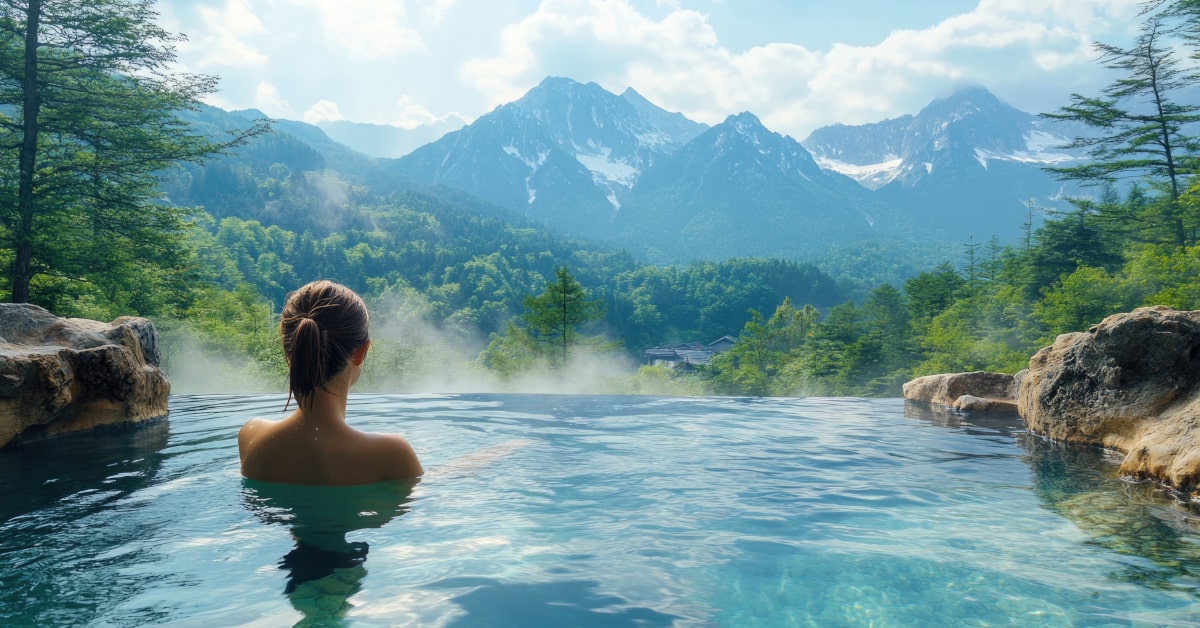 Donna che fa il bagno nell'acqua termale all'aperto con panorama di montagna