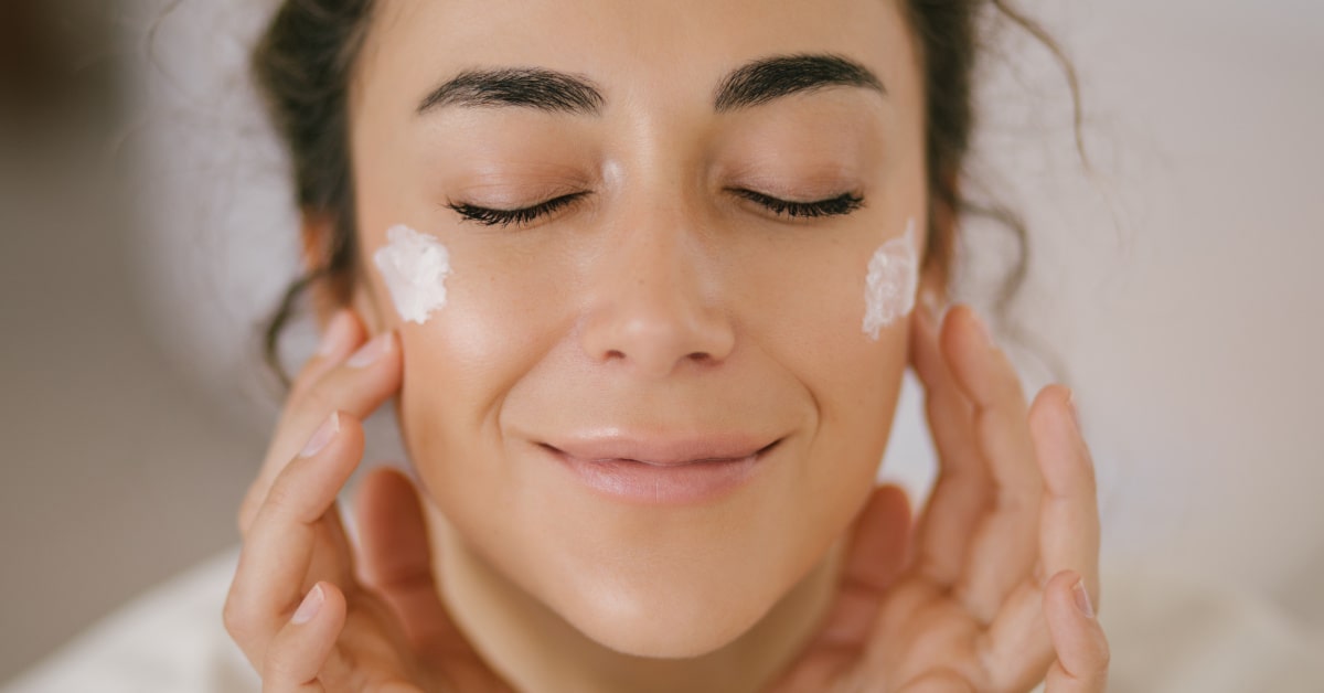 Primo piano di donna che applica la crema viso