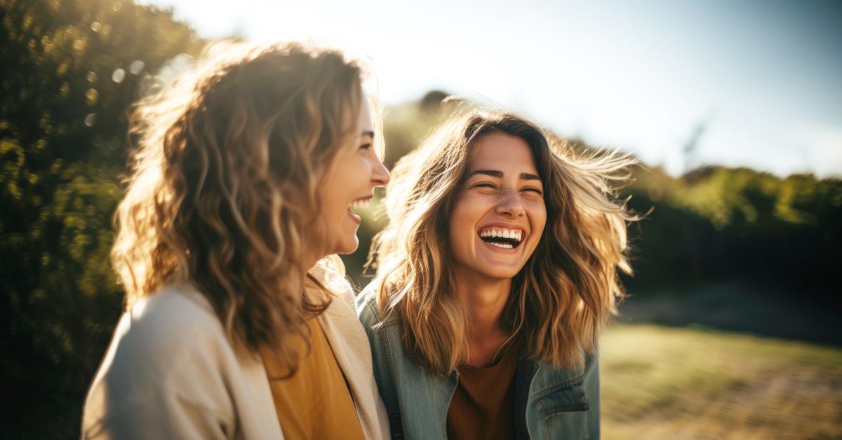 Donne che ridono in un prato al tramonto