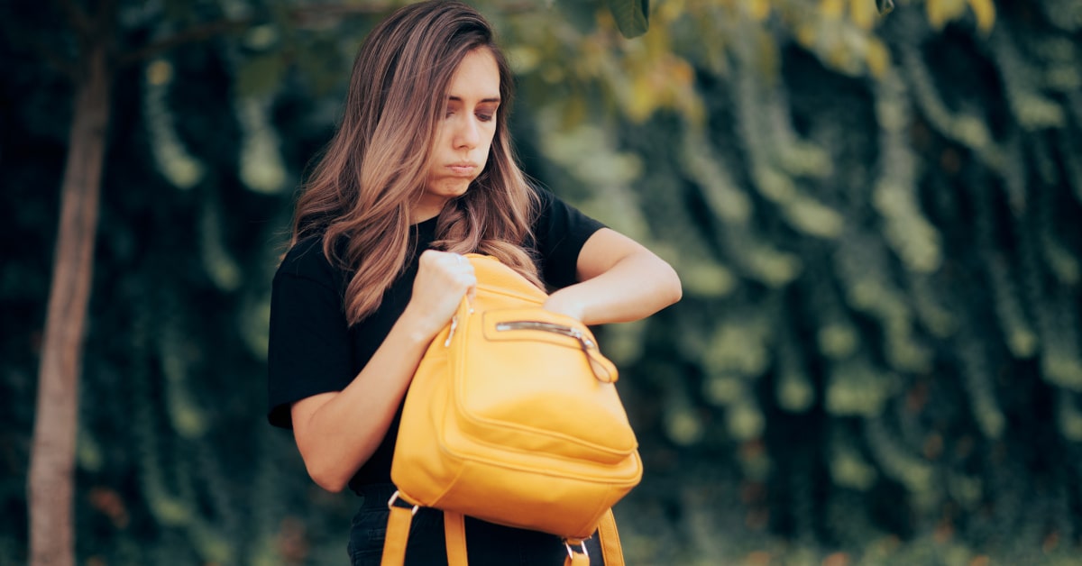 Donna che cerca qualcosa nella borsa ma non riesce a trovarlo
