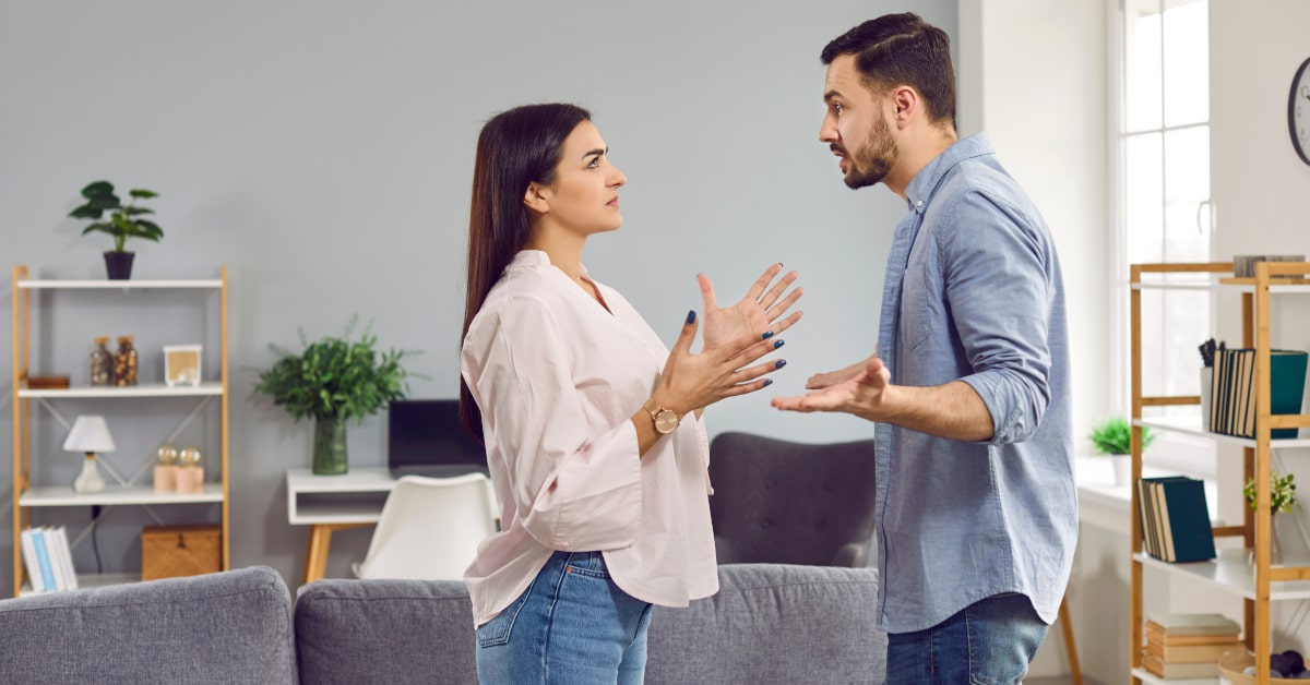 Coppia in piedi in salotto che affronta una discussione difficile