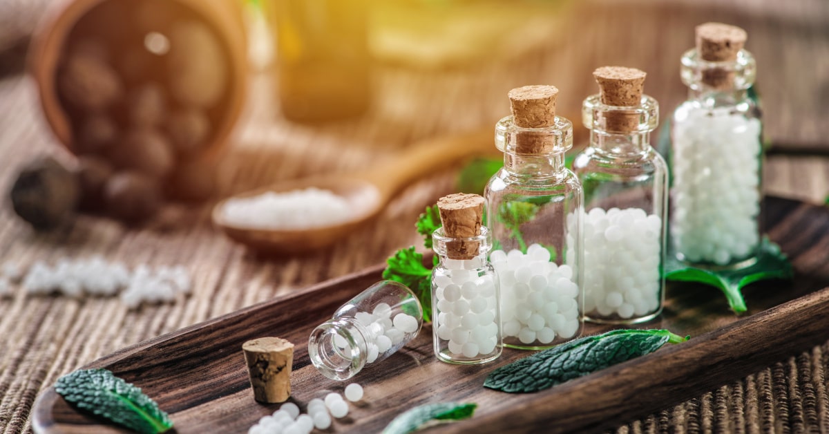 Vassoio con boccette di vetro contenenti granuli omeopatici 