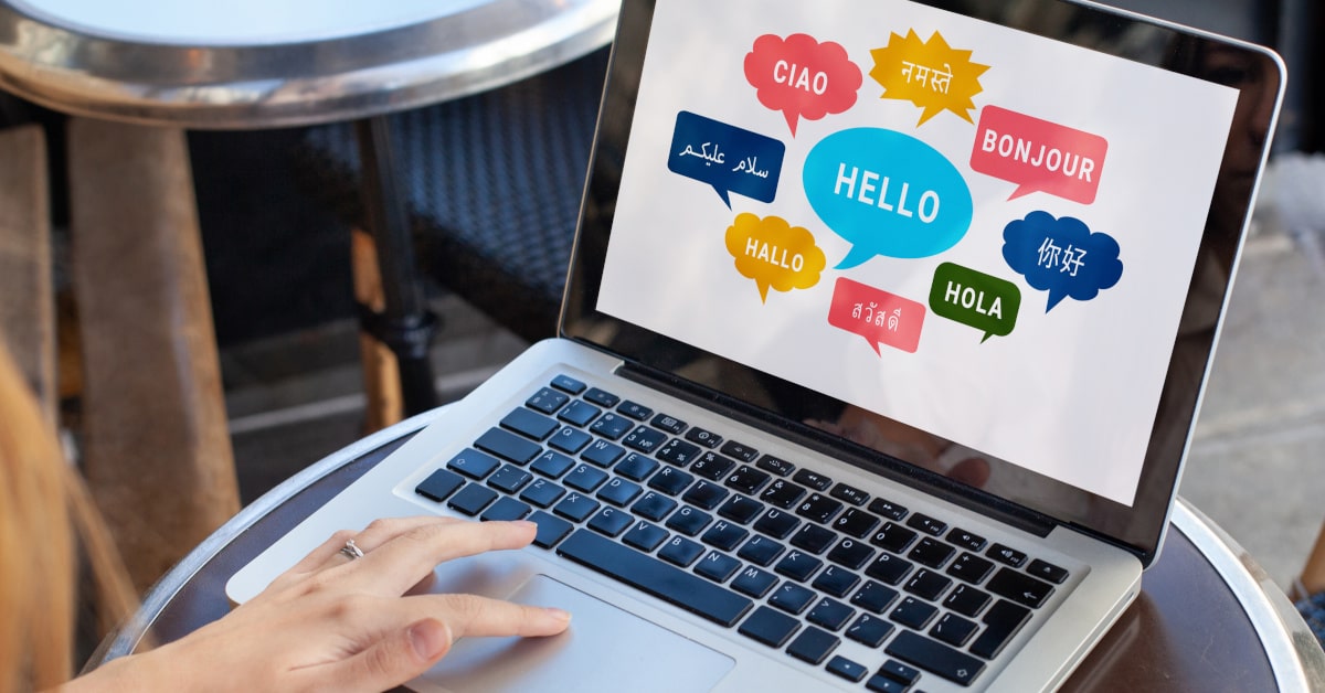 Donna al computer mentre legge il saluto in lingue diverse
