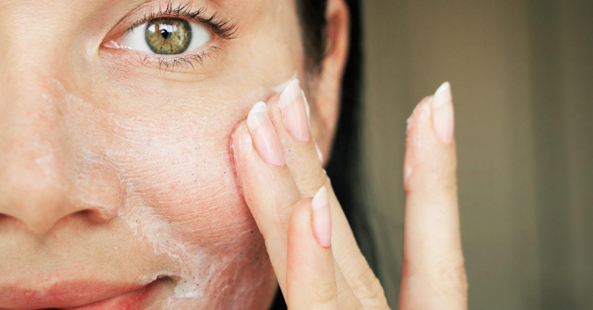 Donna che deterge il viso al mattino con prodotti delicati