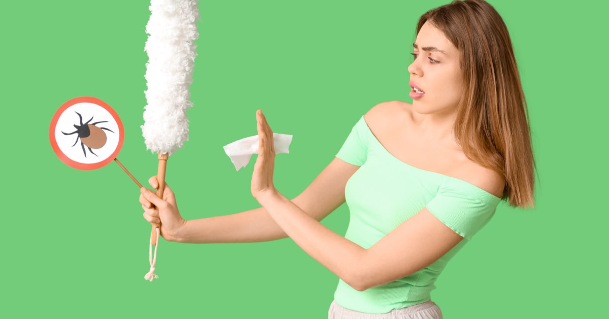 Donna con spolverino e cartello antiacaro, concetto di allergia alla polvere