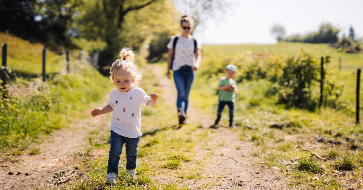 Bambini che camminano su un sentiero in mezzo alla natura con la mamma