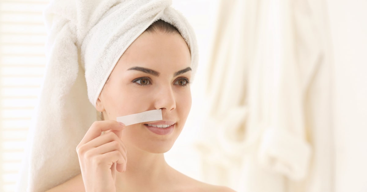 Donna con striscia depilatoria per il viso
