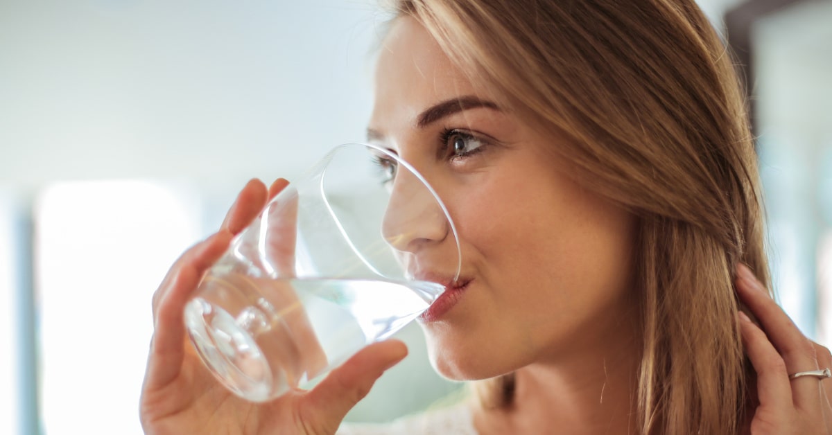 Donna che beve un bicchiere di acqua
