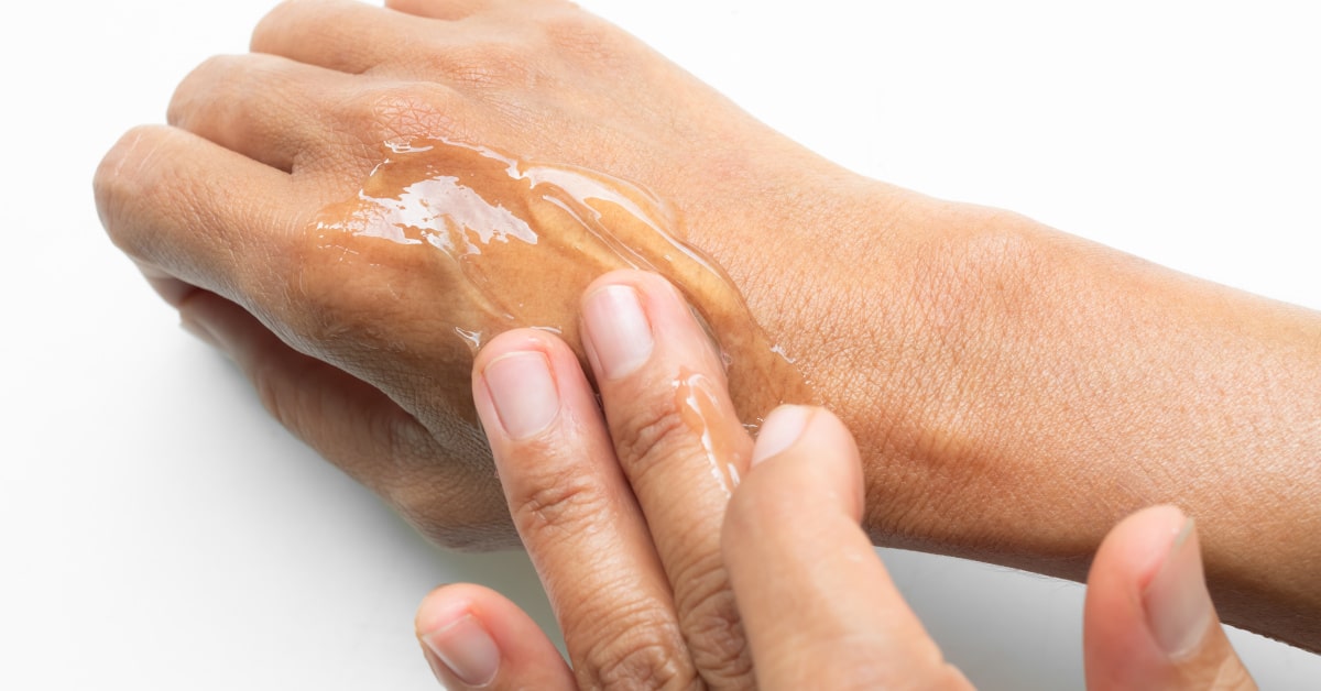 Donna che massaggia del gel di aloe vera sulla pelle del braccio