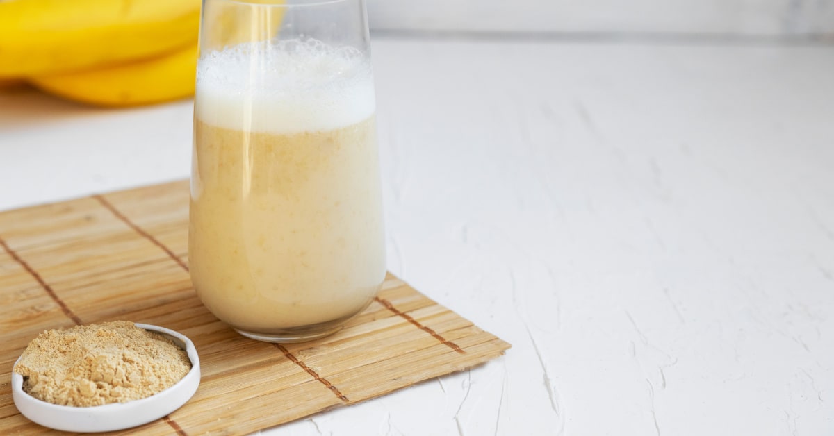 Bicchiere con caffè di maca e polvere di maca in un piattino