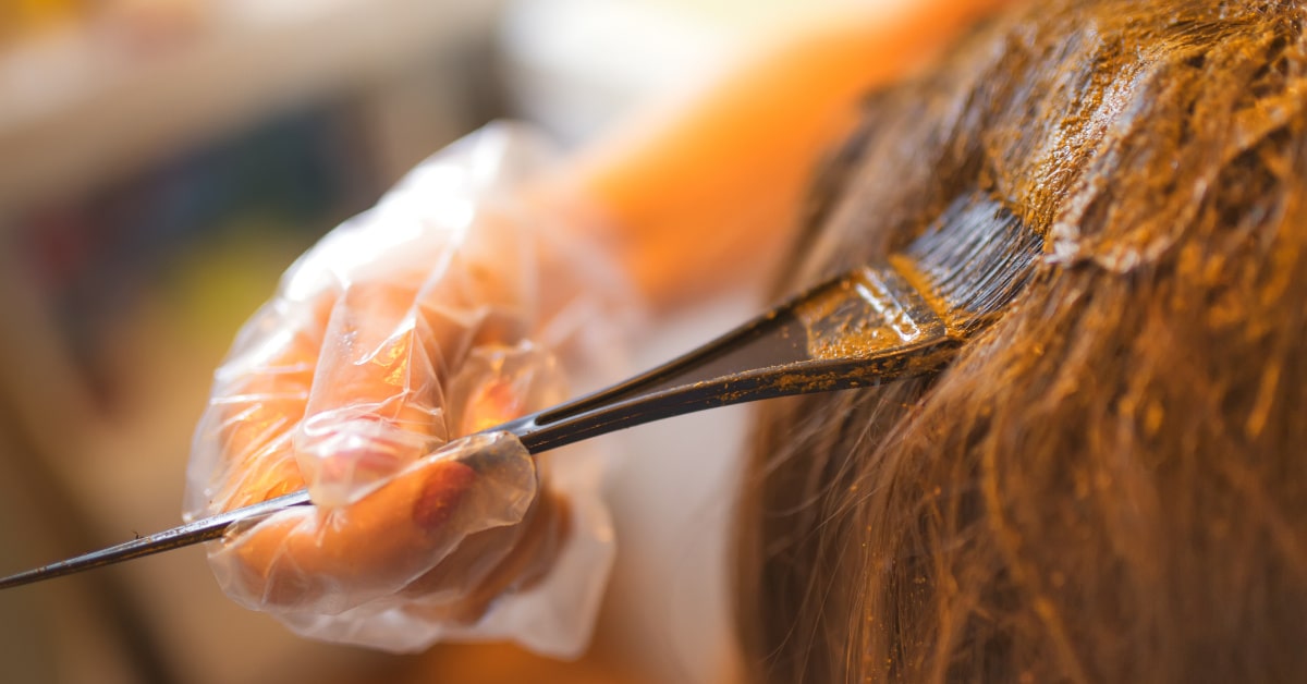 Donna che spalma henné sui capelli per tinta naturale