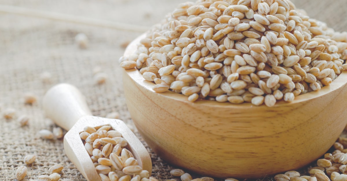 Chicchi di orzo crudi in ciotola di legno