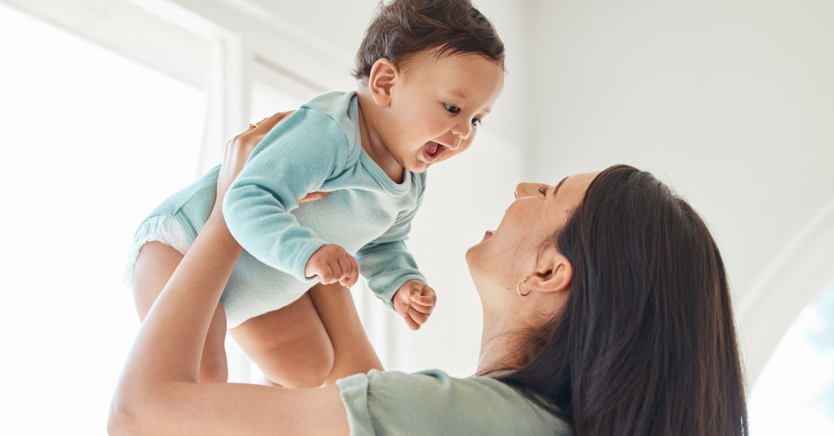 Mamma con il proprio bambino in braccio mentre ridono