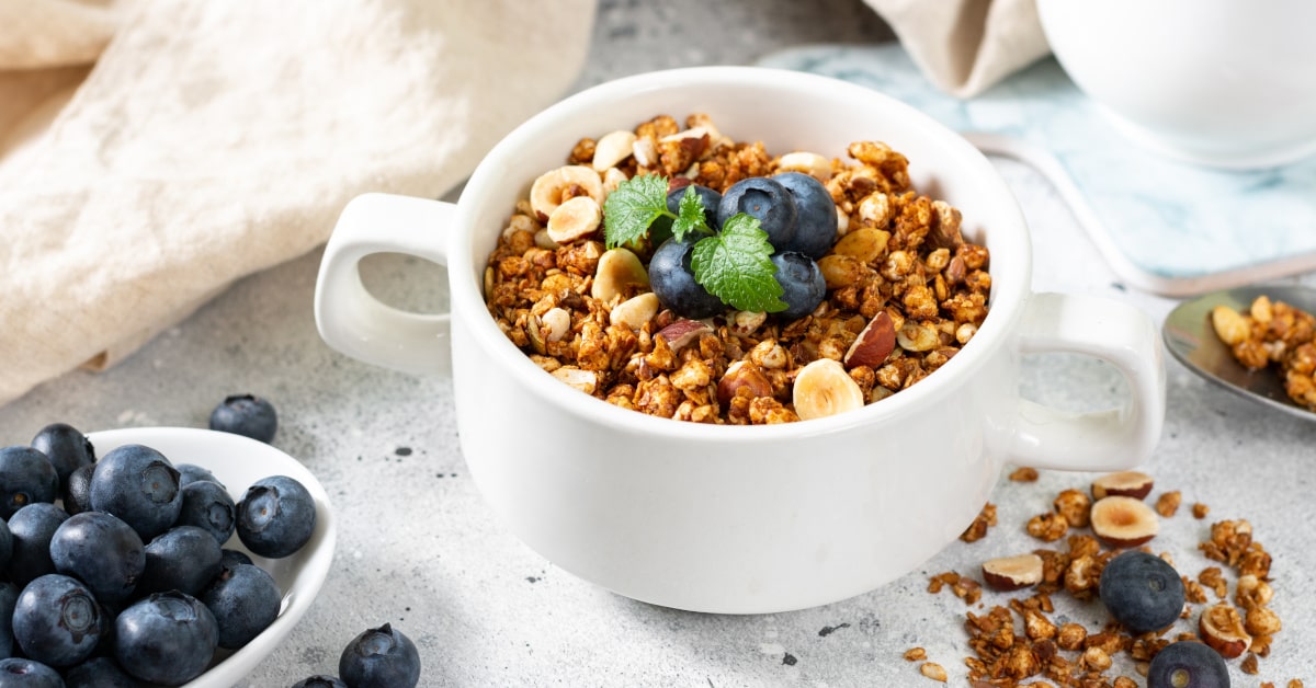 tazza con granola di cereali, frutta secca e mirtilli freschi