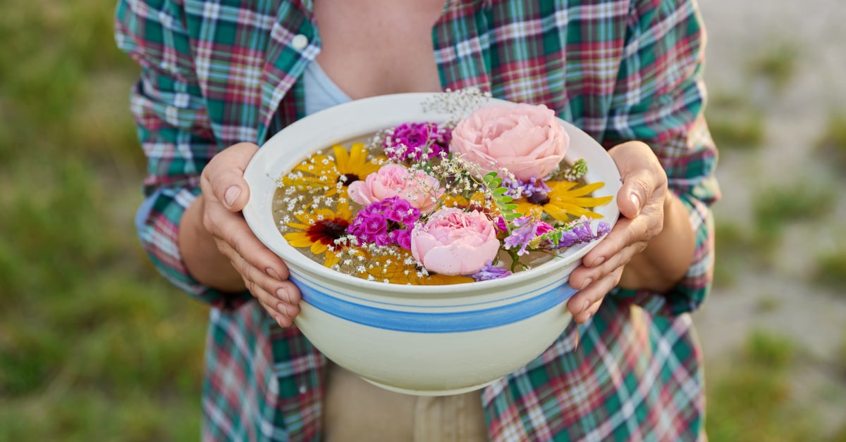 Donna che tiene in mano una ciotola di acqua con fiori 