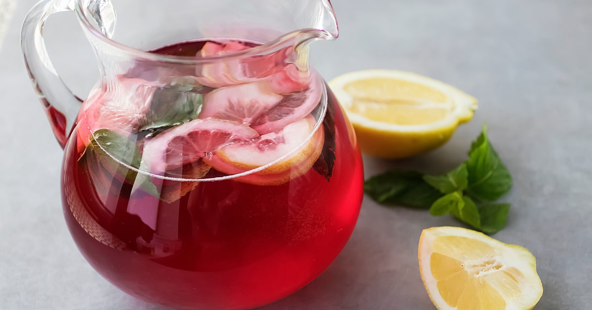 Brocca di acqua con limone e frutti rossi