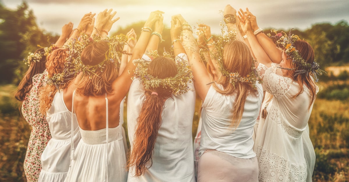 Donne che celebrano in cerchio in mezzo alla natura con una ghirlanda di fiori in testa