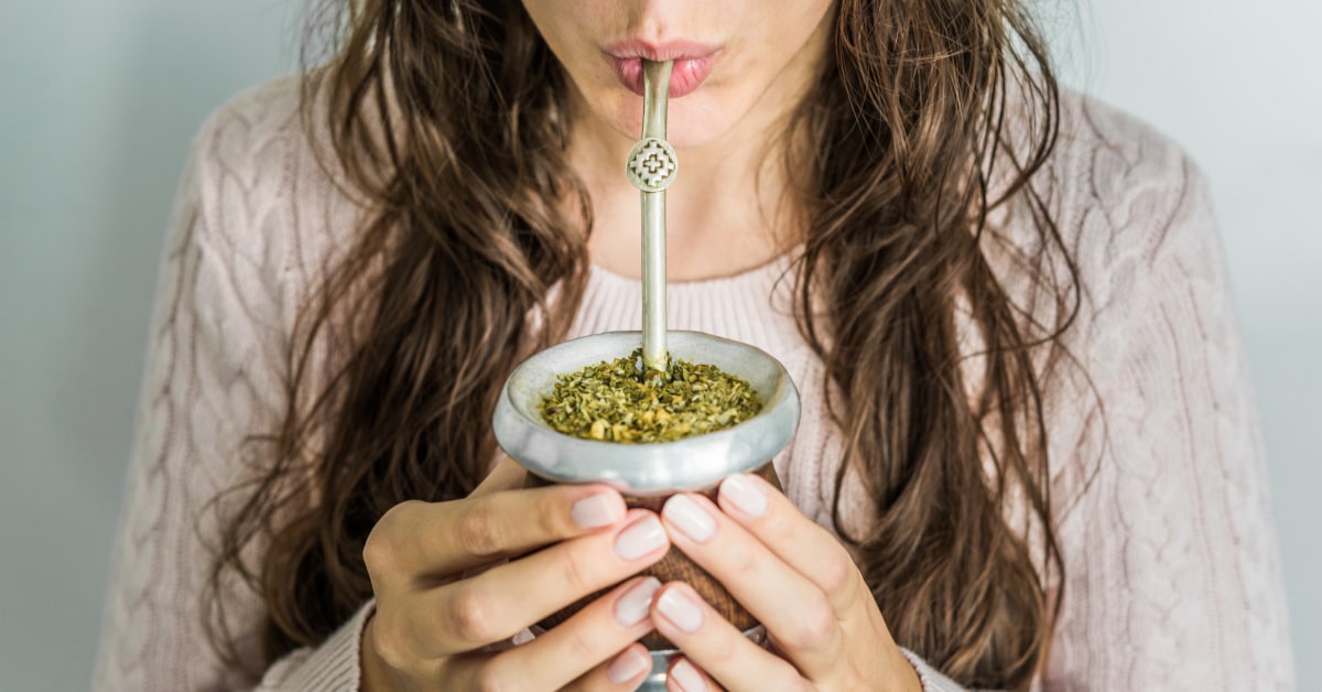 Donna che beve mate con la cannuccia apposita