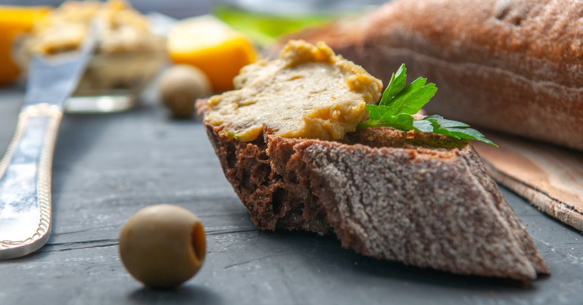 Hummus di olive su una fetta di pane casareccio