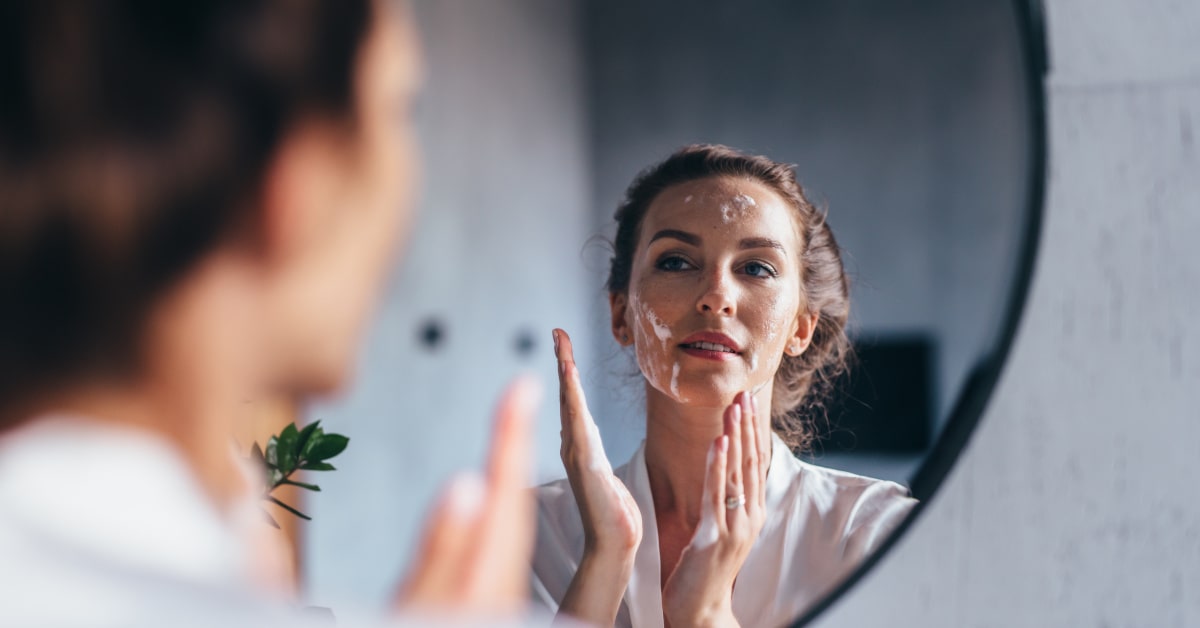Donna che si lava il viso davanti allo specchio