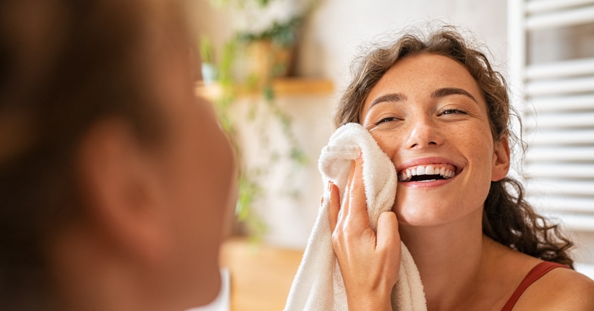 Donna che si asciuga il viso con l'asciugamano