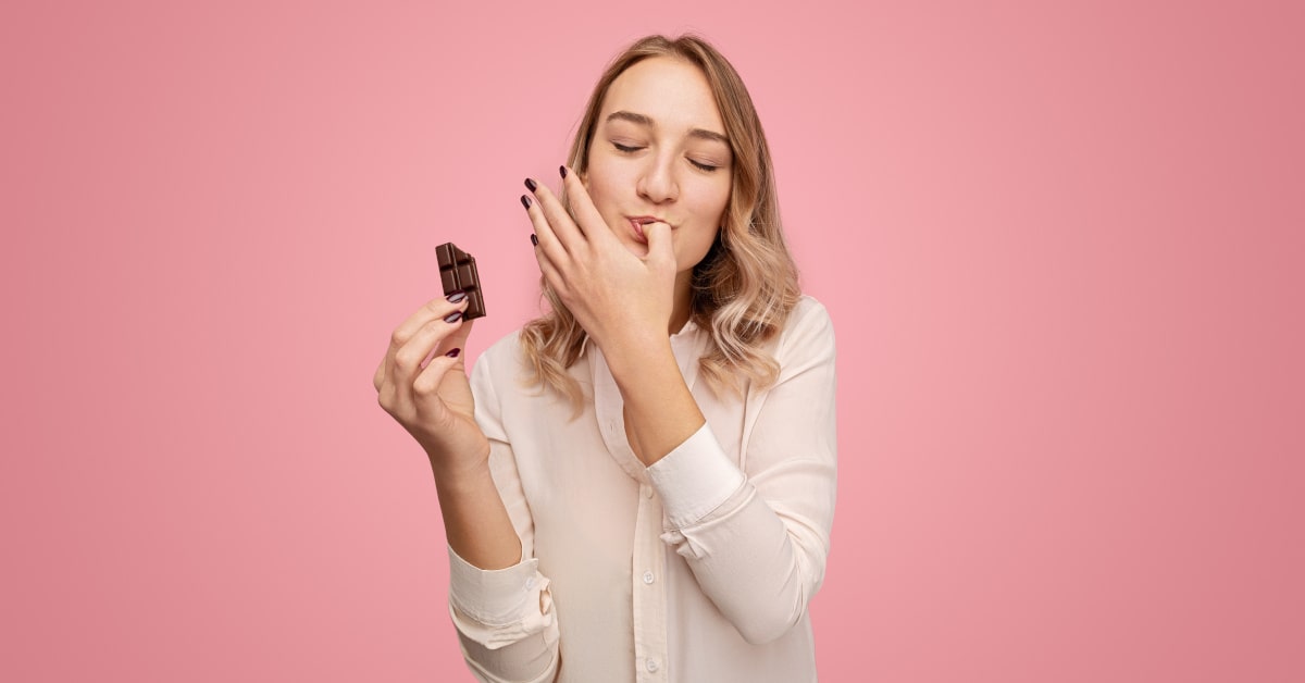 Donna che mangia un pezzetto di cioccolato 