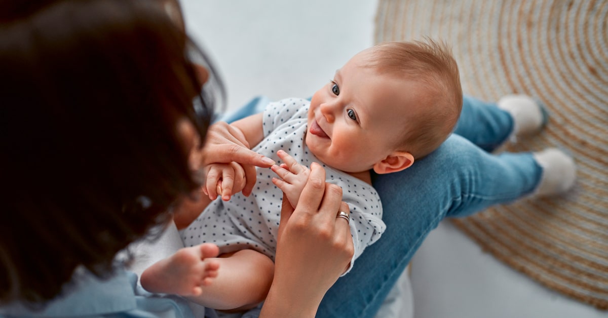 mamma con bambino di qualche mese sulle ginocchia senza ciuccio