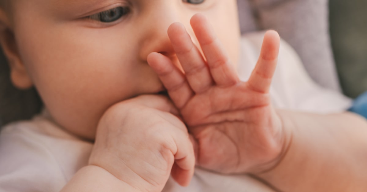 Bambino di qualche mese che succhia il dito