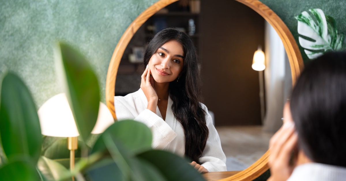 Donna davanti allo specchio del bagno con parete verde
