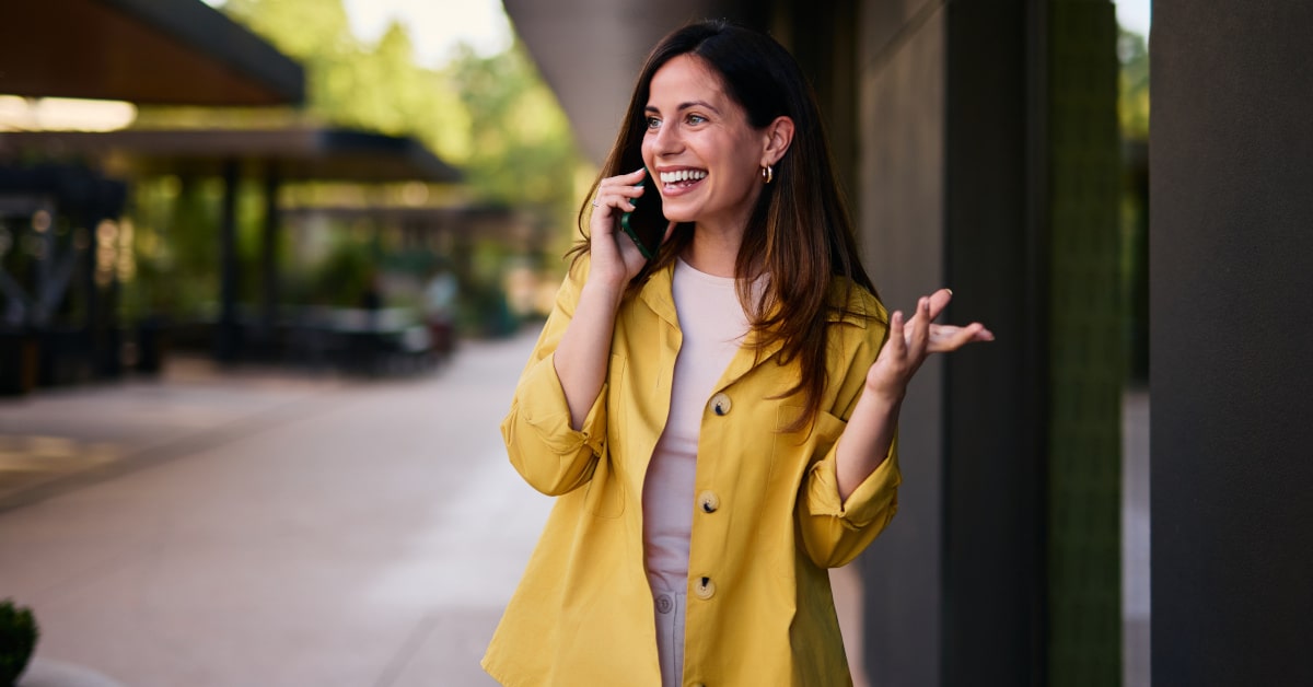 Donna al telefono con giacca gialla