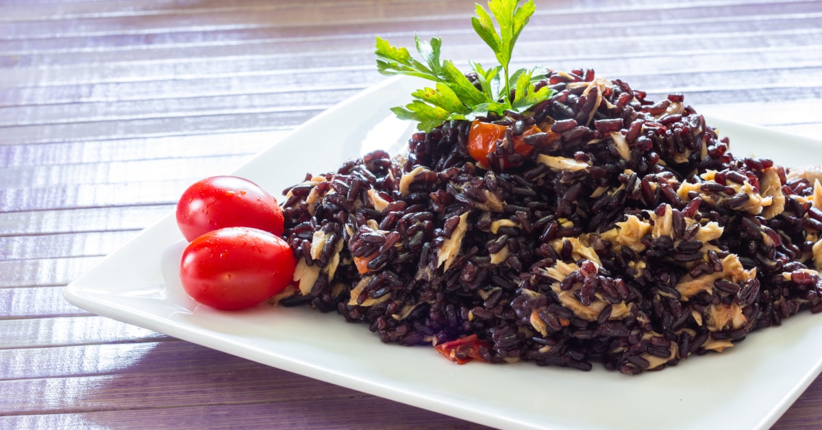 Piatto di riso nero con tonno e pomodorini
