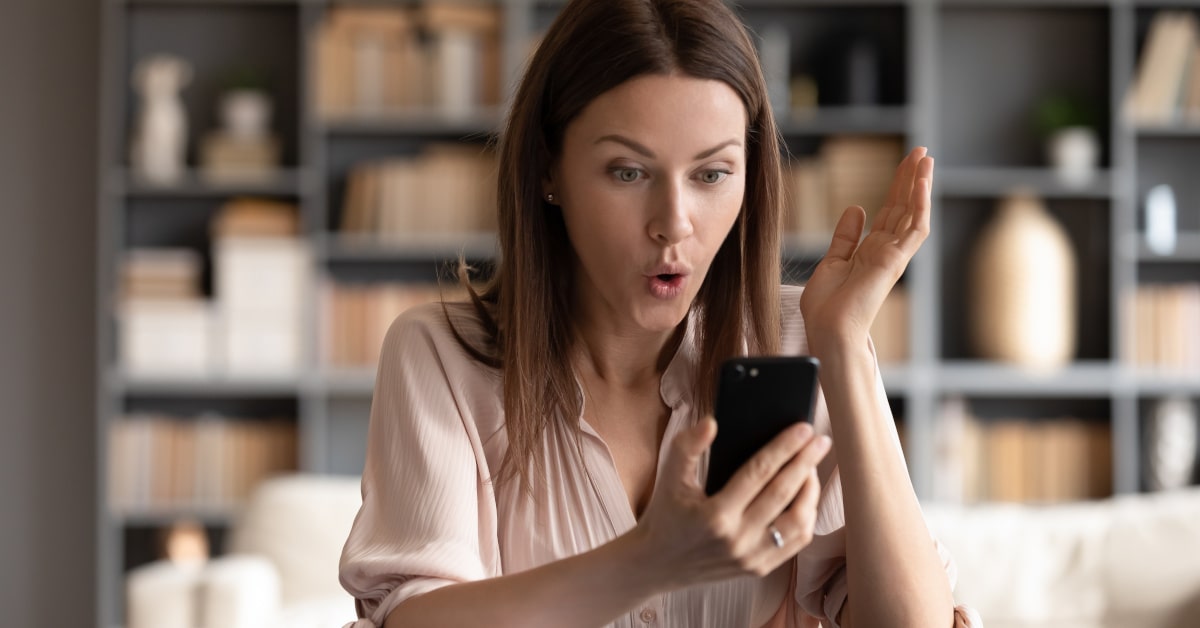 Donna che guarda sorpresa il suo cellulare
