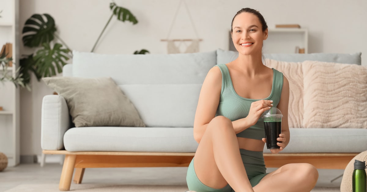 Donna con smoothie proteico con spirulina mentre fa sport