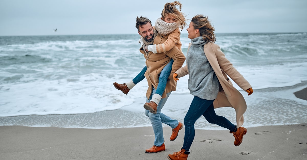 Famiglia che passeggia al mare in inverno