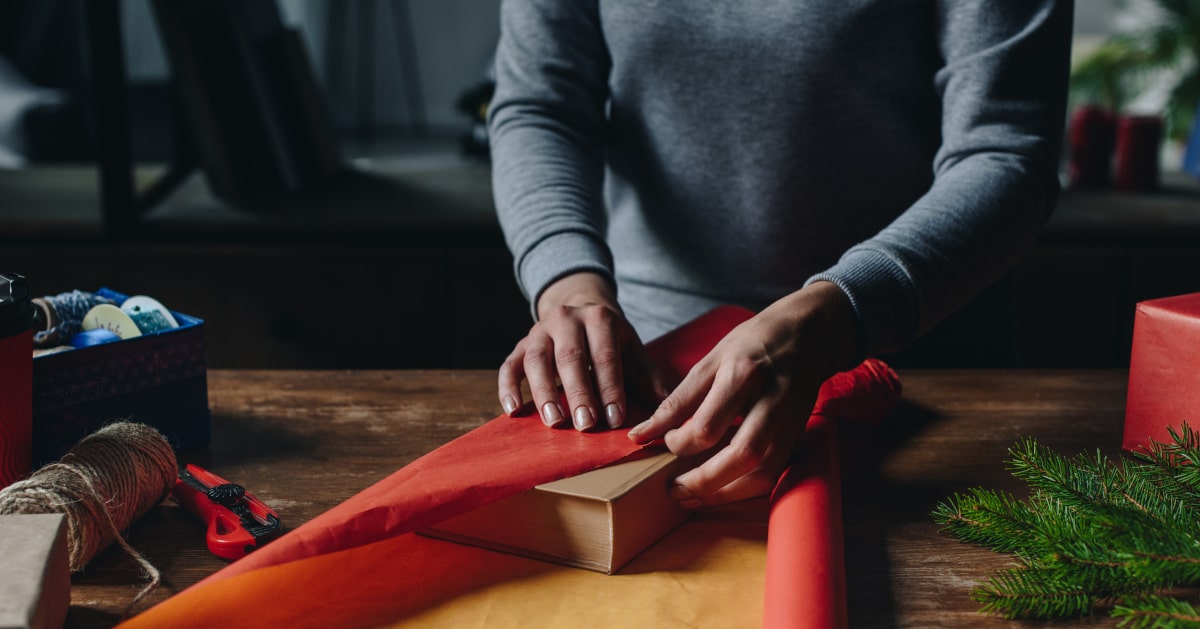 Donna che incarta un libro per Natale