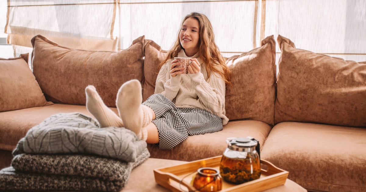 Donna seduta sul divano in un momento di relax in autunno