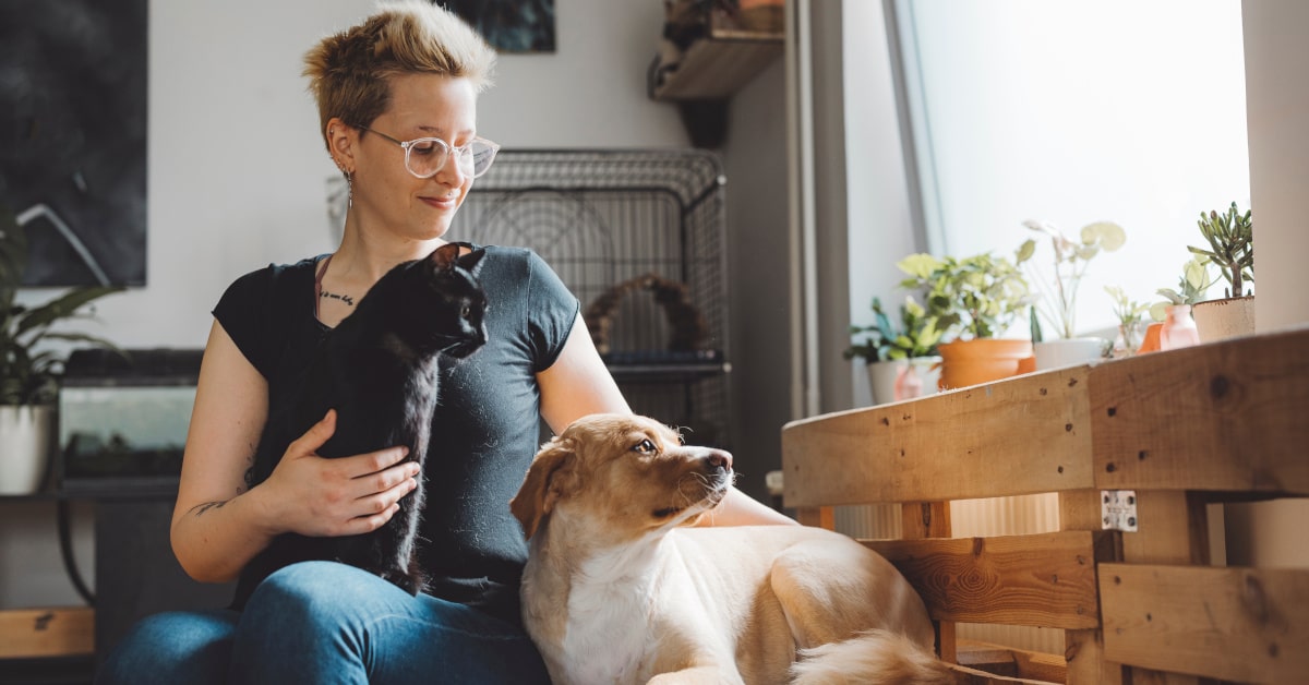 Donna con gatto nero e cane 