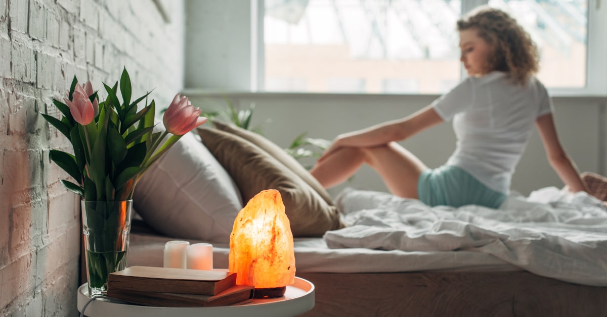 Lampada di sale posizionata in camera da letto con ragazza sullo sfondo