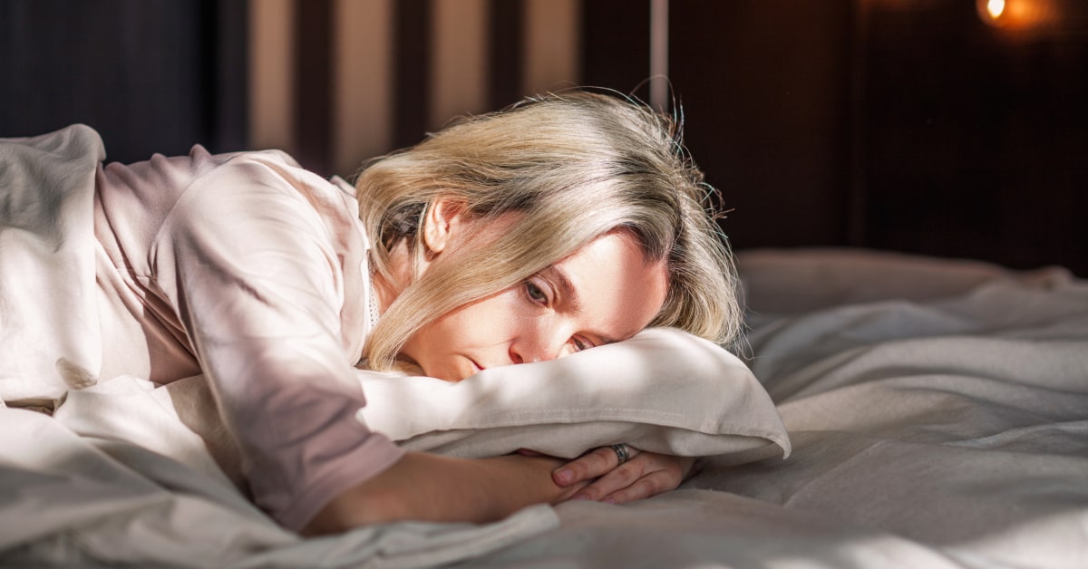 Donna di mezza età stesa a letto con umore depresso e ansia