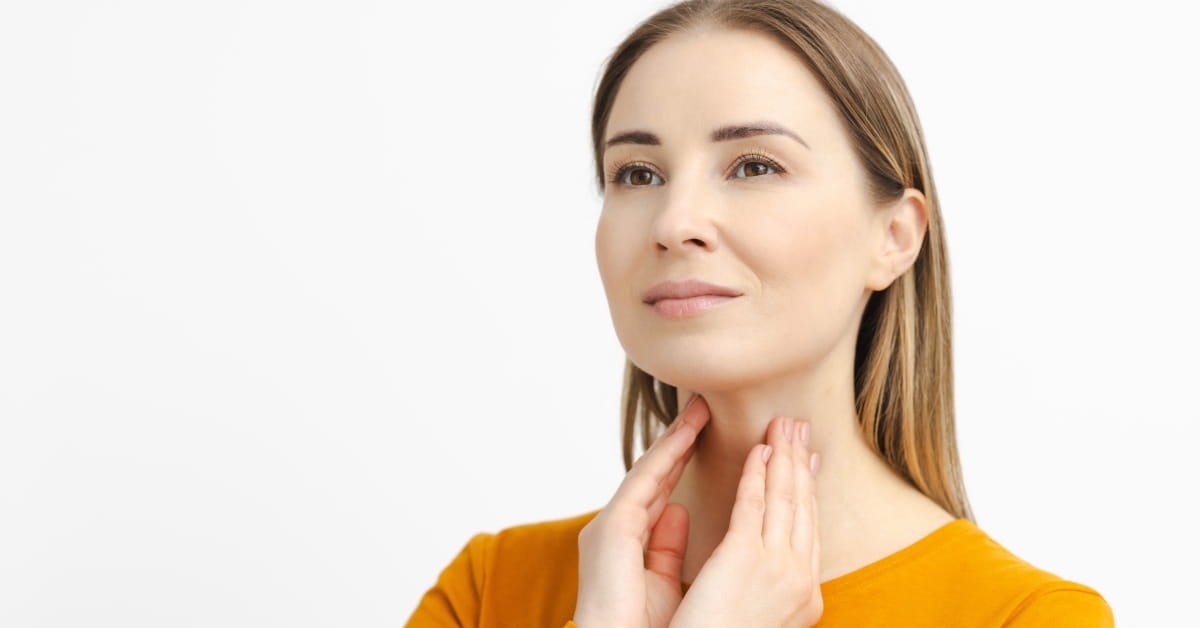 Donna che si palpa la tiroide alla base del collo