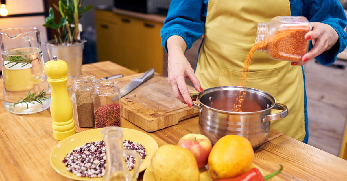 Donna che cucina le lenticchie secche